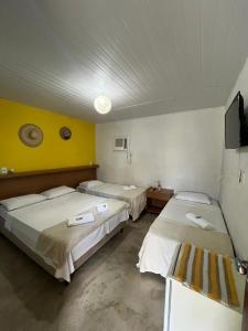 a room with three beds and a tv in it at Pousada In Paradiso in Santa Cruz +17 photos