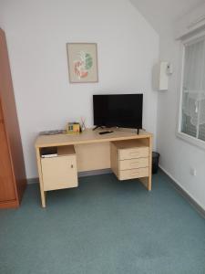 a wooden desk with a television on top of it at Le Nid Douillet in Saint-Berthevin-sur-Vicoin