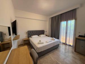 a hotel room with a bed and a television at Lili Hotel in Amoudara Herakliou