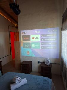 a projection screen in a room with a bed at Chalé Jardim Mágico in Milho Verde