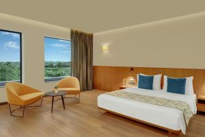 a hotel room with a bed and a large window at The Fern Residency, Jamnagar, Series by Marriott in Jamnagar