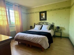 a bedroom with a bed with a black and white comforter at Maison familiale in Paulhac