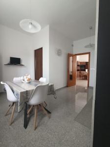 a dining room with a table and white chairs at Tra mare e vigneti in Ortona +18 photos