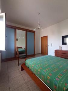 a bedroom with a bed and a chair in it at Tra mare e vigneti in Ortona