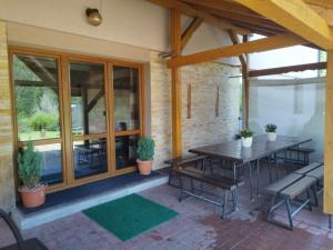 a patio with a table and chairs and windows at Dom w górach na wyłączność Agro Zibi in Korbielów