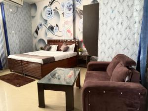 a bedroom with a bed and a couch and a table at HOTEL The Puadh Stay in Lāndrān +1 photo
