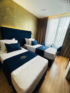 a hotel room with two beds and a window at Hotel Shopi Residence in Elbasan
