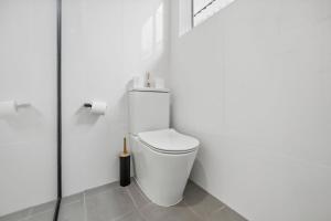 a bathroom with a toilet in a white room at Lovely Hidden Gem in Redcliffe in Redcliffe +25 photos