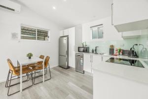 a kitchen with a table and chairs and a refrigerator at Lovely Hidden Gem in Redcliffe in Redcliffe