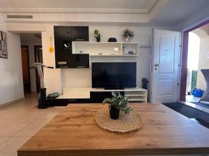 a living room with a table and a tv at Altos Bahia Magic in Torrevieja