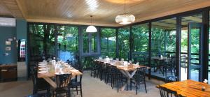 a dining room with tables and chairs and windows at Martvili canyon cottage in Martvili