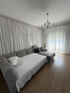 a large white bed in a bedroom with a chandelier at Apartment Lana in Baška Voda