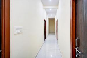 a corridor of an office with white walls and white tile floors at Hotel O Hotel Denmark in Chinhat