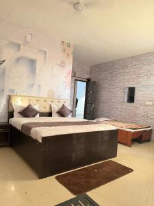 a bedroom with a large bed and a brick wall at HOTEL The Puadh Stay in Lāndrān