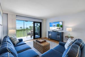 a living room with a blue couch and a tv at South Seas Beach Villa 2428 in Captiva