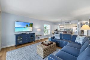 a living room with a blue couch and a kitchen at South Seas Beach Villa 2428 in Captiva