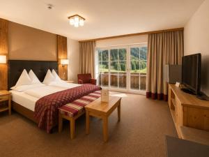 a hotel room with a bed and a television at Hotel Das Urbisgut in Altenmarkt im Pongau