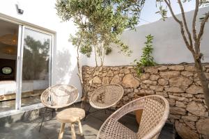 a group of chairs and a table and a stone wall at Villa Sahel Bleu in Essaouira