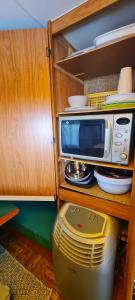 a microwave sitting on a shelf in a kitchen at Tiny Anna's Cozy Home near Redbull Ring in Liesingthal