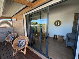 a screened in porch with chairs and a table at O coeur de l'ouest Bungalow Maloya in Le Bois de Nèfles