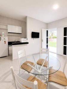 a kitchen and dining room with a glass table and chairs at Brisa do Preá- 700m da Praia do Preá -12km de Jeri in Prea