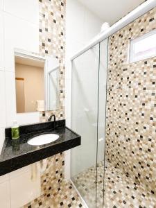 a bathroom with a sink and a glass shower at Brisa do Preá- 700m da Praia do Preá -12km de Jeri in Prea +34 photos