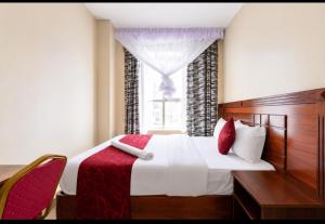 a bedroom with a large bed and a window at Capital comfort Hotel Ambala Rd in Nairobi