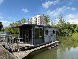a small house on a boat in the water at Hausboot Luft & Liebe in Halle an der Saale