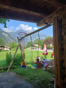 a swing set with a child sitting on it at LOCANDA Alla Paia in Pracul