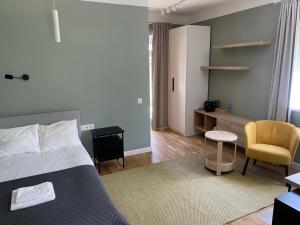 a bedroom with a bed and a desk and a chair at "Pas draugą" Šalkauskio g in Kaunas