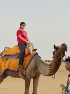 a woman riding on the back of a camel at Hotel Robin Jaisalmer Near fort view in Jaisalmer +23 photos