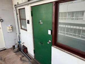 a green door on the side of a building at Roxy inn in Oita