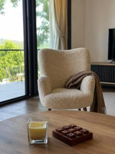 a glass of orange juice on a table next to a chair at Villa Vasilije in Šavnik