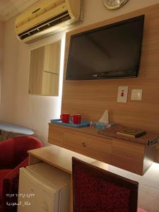 a room with a flat screen tv on a wall at فندق سكب الأصيل in An Naqāʼ