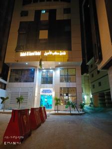 a building at night with palm trees in front of it at فندق سكب الأصيل in An Naqāʼ