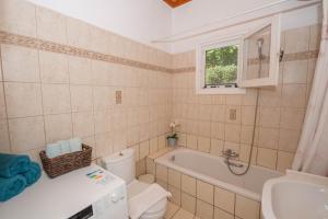 a bathroom with a tub and a toilet and a sink at Ilia's Holiday Home in Perítheia +28 photos