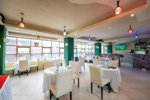 a dining room with white tables and chairs at Capital comfort Hotel Ambala Rd in Nairobi