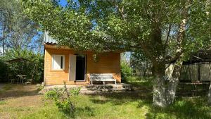 a small house with a bench next to a tree at Voyage in Sevan +17 photos