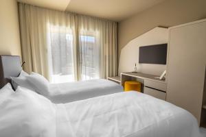 a hotel room with two beds and a window at Suni Rural Relax in Suni