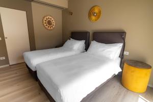 two beds in a room with white sheets at Suni Rural Relax in Suni