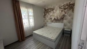 a small bedroom with a bed and a window at Voyage in Sevan