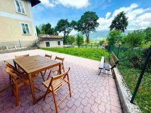 a wooden table and chairs on a brick patio at Cuori, Cervi e Caprioli in Cesuna +34 photos