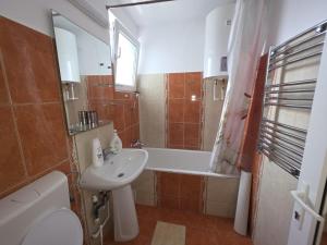 a bathroom with a sink and a toilet and a bath tub at Apartament Gabriela in Mangalia