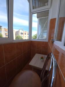 a small table in a room with two windows at Apartament Gabriela in Mangalia