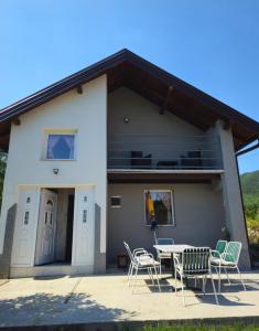 a house with a table and chairs in front of it at Vikendica Stanković in Šipovo