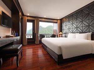a bedroom with a large bed and a large window at Aqua of the Seas Cruise in Ha Long