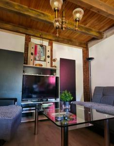 a living room with a tv and a glass table at Vikendica Stanković in Šipovo