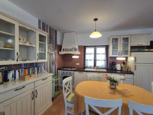 a kitchen with a table and white cabinets at Villa Ester in Rovinj