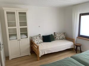a room with a bed and a couch and a cabinet at Fewo Fernblick in Much