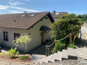 a small yellow house with a staircase in front of it at Fewo Fernblick in Much